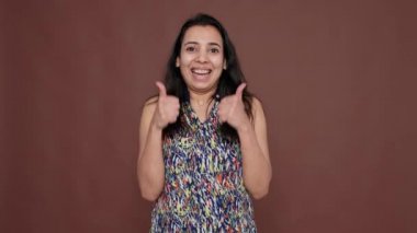 Hint modeli stüdyoda olumlu bir işaret ve olumlu bir jest gösteriyor. İyimser bir fikre katılıyor ve veriyor. Arkadaş canlısı olumlu onay mükemmel bir anlaşma için tamam sembolü.