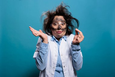 Kimyasal patlamadan sonra mikroskobik örneğe bakan aptal ve çılgın bir biyokimyacı. Pis saçlı ve kirli yüzlü çılgın bilim adamı kollarını silkerken kameraya şaşkın bakıyor..