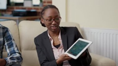 İş arkadaşları dizüstü bilgisayarda iş geliştirmek için takım çalışması yapıyorlar, kanepede oturuyorlar. Başlangıç büyümesi için finansal tablolar sunumunda işbirliği yapmak üzere toplanan bir grup insan.