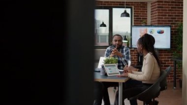 İş adamlarından oluşan bir ekip dijital tablet ve dizüstü bilgisayardaki veri istatistikleriyle finansal analiz üzerinde çalışıyor. Ofis çalışanları beyin fırtınası yapmak ve strateji planı üzerinde takım çalışması yapmak için toplanıyor..