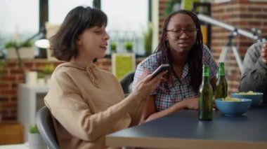 Milenyum insanları sosyal medya mimiklerini cep telefonuyla paylaşıyor, online internet ve modern teknoloji ile eğleniyorlar. Bir grup arkadaş akıllı telefon ağı uygulaması ile birlikte gülüyor.