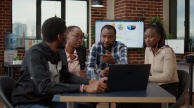Afrika kökenli Amerikalılardan oluşan bir ekip proje brifingi vermek, fikir üretmek ve iş büyümesine çözüm bulmak için toplantı odasında toplanıyor. Takım çalışması yapan ve sunumda işbirliği yapan insanlar.