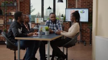 Finansal proje üzerinde takım çalışması yapan şirket çalışanları, istatistik grafikleri ve veri grafiklerini analiz etmek için dijital tablet ve dizüstü bilgisayar kullanıyorlar. Sunum için işbirliği yapan bir grup insan. Beyin fırtınası fikirleri.