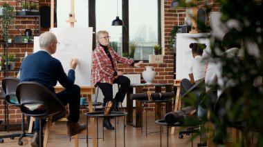 Sanat okulu programındaki insanlara çizim becerilerini açıklayan yaşlı bir sanatçı, onlara kişisel gelişim için profesyonel çizimler yapmayı öğretiyor. Hobi yapmak için atölye çalışması. Üçayak atışı