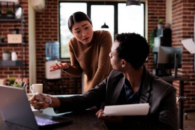 Tekerlekli sandalyede oturan ve Asyalı kadınla iş belgeleri üzerinde çalışan bir proje yöneticisi. Kronik engelli çalışan ve iş kadını engelli bürosunda beyin fırtınası yapan bir çalışan..