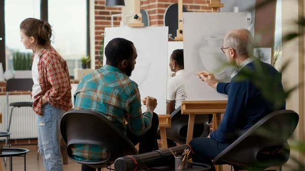 Team of young man and elder person attending art school class together to learn drawing skills for personal development and growth. Educational program to draw artwork sketch.