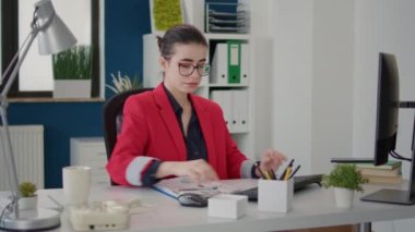 İş stratejisini geliştirmek için pazarlama çizelgeleriyle çalışan bayan çalışanlar monitörde. Araştırma analisti şirket büyümesi yaratmak için bilgisayar ve dosyalarda finansal grafikler kullanıyor.