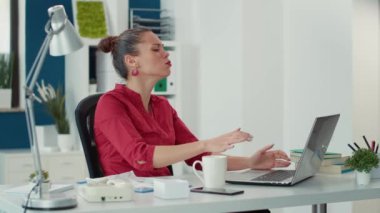 Başlangıç ofisindeki iş sorununu çözmek için dizüstü bilgisayar kullanan bitkin bir kadın araştırma başarısızlığından rahatsız oluyor. Veri tabloları ve satış diyagramı ile çalışan yorgun işçi.