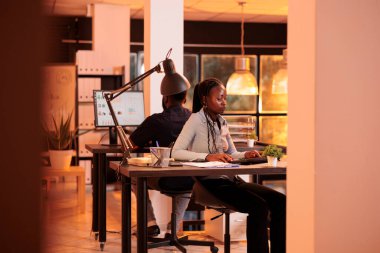 Şirket çalışanı ofisteki bilgisayardaki araştırma verilerini analiz ediyor, yöneticiye e-posta raporu hazırlamak için yönetici bilgileriyle çalışıyor. Bilgisayardaki yönetim belgelerine bakıyorum..