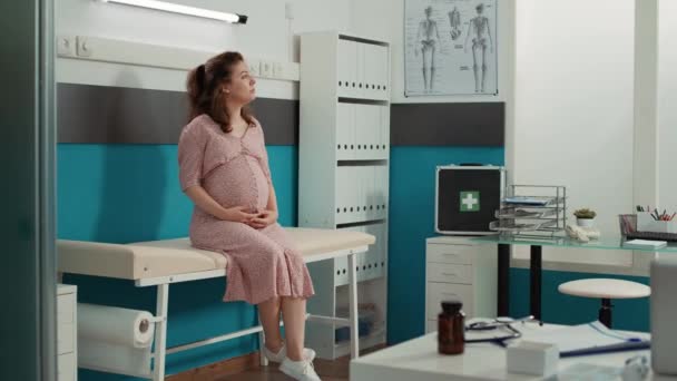 Portrait of woman expecting child at medical appointment with doctor, doing consultation in cabinet. Person with pregnancy belly waiting to attend examination with male physician.
