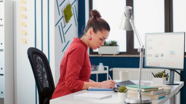 Satış analisti iş belgeleri hakkında istatistik raporu yazıyor, bilgisayardaki veri grafiklerini ve grafiklerini analiz ediyor. Pazarlama uzmanı mali asistanı yeni strateji üzerinde çalışıyor.