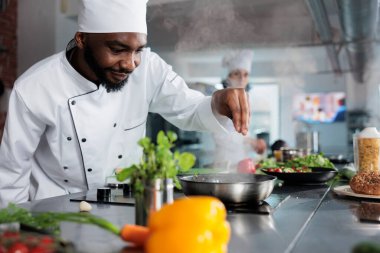 Lokanta mutfağında parmesan peyniri ile garnitür hazırlama konusunda usta bir gastronomi uzmanı. Aşçı taze otlar ve organik sebzelerle yemek hazırlıyor..