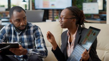 İş adamları pazarlama raporu oluşturma, dosya istatistikleri ve takım çalışması için dizüstü bilgisayarların istatistiklerini analiz etme konusunda beyin fırtınası yapıyorlar. Sunum planlamak için işbirliği yapan bir grup iş arkadaşı. El kamerasıyla..