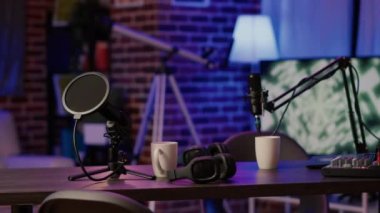 Boş video kaydedici masasındaki kulaklıklar ve profesyonel mikrofonlar internette canlı yayına hazır. Çevrimiçi podcast yayınları için boş masadaki ikili vlog için ekipman ayrıntıları.