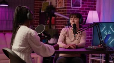 İçerik yaratıcısı, kendi stüdyomuzda sosyal medya sayfası için ünlü bir etkileyiciyle podcast yapıyor. Çevrimiçi radyo sunucusu gece yarısı eğlence programında Afrikalı Amerikalı şarkıcıyla röportaj yapıyor..