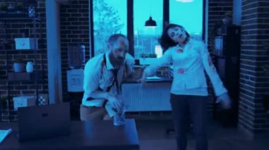 Tehlikeli ofis zombileri gece çalışma alanında kameraya doğru koşuyor. Derin ve kanlı yara izleri olan korkunç, çirkin beyin yiyen canavarlar iş yerlerinde homurdanarak dolaşıyorlar. El bilgisayarı