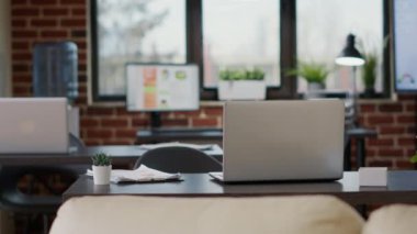 Şirket çalışanı tarafından finansal büyüme planlamak için kullanılan dosya ve dizüstü bilgisayarı olan kimse yok. Ekranda bilgisayar, teknoloji ve pazarlama istatistikleri bulunan boş iş yeri.