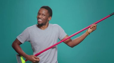 Süpürgeyle gitar çalan aptal şarkıcının portresi, arka planda çocukça bir performans hakkında olumlu düşünüyor. Gülümseyen neşeli adam eğlence için komik enerji gösteriyor..