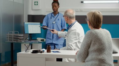 Emekli kadın, hastalıkları tedavi etmek için ilaç ve reçeteli ilaçlar için randevu kağıtları imzalıyor. Tedaviyle hastalıktan kurtulmak için sağlık sistemindeki tıbbi belgelere imza atıldı.