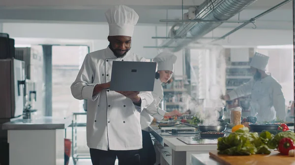 African American Σεφ Μαγειρική Συνταγή Φορητό Υπολογιστή Κάνει Προετοιμασίες Γεύμα — Φωτογραφία Αρχείου