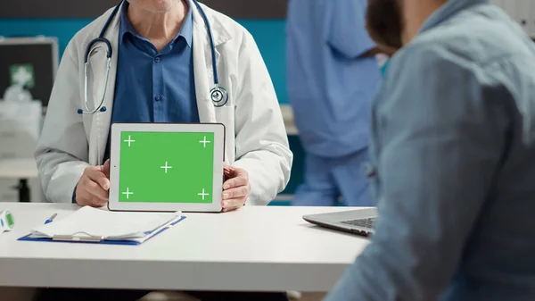 Health specialist showing horizontal greenscreen on tablet, patient looking at display. Mockup isolated template with blank copyspace and chroma key background on gadget. Close up.