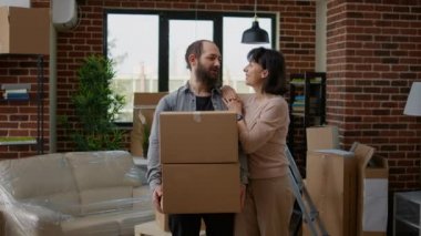 Yeni bir eve taşınmak için karton kutuları olan insanların portresi. Evli çift mobilyalarını ve apartmanlarını boşaltıyor, kiralık bir daireye taşınıyor..