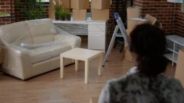 Evli çift taşınan karton kutuları satın alınmış gayrimenkullere istifliyor. Oturma odasındaki daireyi dekore etmek için paketleri boşaltıyorlar. Yeni başlangıçlar için mobilyalarla aynı eve taşınmak, ev almak..