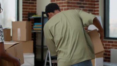 Afrika kökenli Amerikalı çift yeni bir daireye taşınmak ve yeni bir başlangıç yapmak için karton kutular kullanıyor. Kiralık bir mülkün ipotek kredisiyle taşınması. El kamerasıyla..