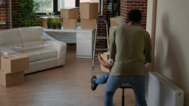 Hayat arkadaşları yeni bir eve taşınırken eğleniyor, kadınları sandalyeye oturtuyor ve ev dekorasyonunun tadını çıkarıyor. Kiralık dairede yeni başlangıçlar ve taşınma günü için neşeli hissediyorum..