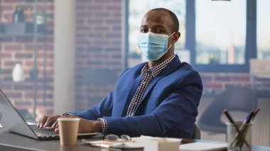 İş projesi yaratmak için dizüstü bilgisayarı kullanarak internet sitesinde erkek danışman istatistiklerinin portresi. Araştırma uzmanı raporla çalışıyor, salgın sırasında internette geziniyor. Kapat..