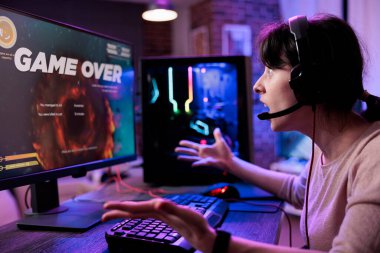 Genç oyuncu bilgisayarda video oyunları turnuvasını kaybediyor. Atış yarışmasını kaybettiği için üzülüyor. Canlı yayında online Rpg aksiyon şampiyonluğu oynayan bayan oyuncu.