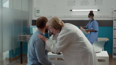 Doktor otolog, kovan 19 salgını sırasında otoskoplu hastanın kulak enfeksiyonunu inceliyor. Sağlık uzmanı, sağlık kontrolünde otoloji aracını kullanarak danışmanlık yapıyor..