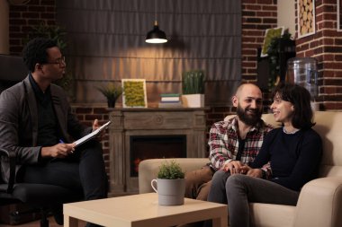 Evli insanlar uzlaşma konusunda mutlu ve ilişki sorunlarını erkek terapistin yardımıyla çözüyorlar. Danışman tavsiyesi almak için çift terapisine katılmak, el ele tutuşmak..