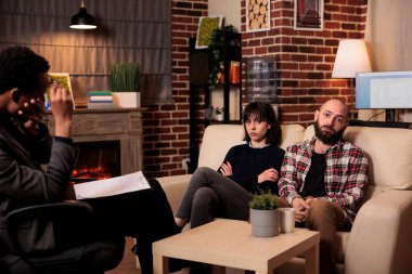 Terapi seansında danışmanla konuşan üzgün ortakların portresi, terapistle ilişki sorunlarını çözmeye çalışmak. Evlilik danışmanlığında sorunlarla uğraşmak.