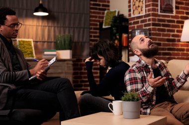 Terapi seansında sırt sırta mücadele eden evlilik sorunları olan bir çift terapistten profesyonel yardım ve tavsiye istiyor. İlişki sorunları hakkında anlaşmazlıklar ve tartışmalar.