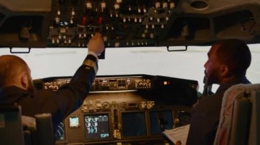 Çeşitli kaptan ve yardımcı pilot takımları uçakla kalkışa hazırlanıyor, torpido gözünde yön bulma düğmelerine basıyorlar. Kontrol paneli kullanarak, güç motorlu bir uçak jeti uçurmak. El kamerasıyla..