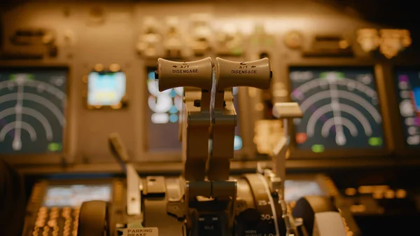 Airplane captain taking off and throttling engine to fly aircraft, using dashboard command with power buttons and lever. Windscreen and control panel used by aircrew. Close up.