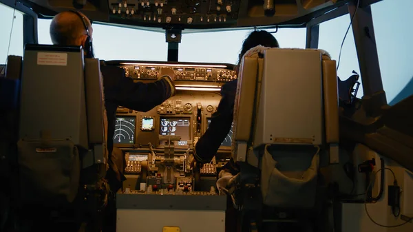 机长和副驾驶在驾驶舱仪表盘上插入目的地坐标 并将高度和经度水平固定在仪表盘上 使用控制面板来驾驶飞机起飞 — 图库照片