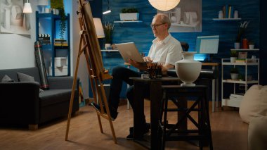 Dizüstü bilgisayarda sanatsal ilhamı bulmak için internette gezinen yaşlılar, çizim yapmak için teknolojiyi kullanıyorlar. Yaratıcı yetenekleri ve sanatsal araçları olan sanat eseri çizimi.