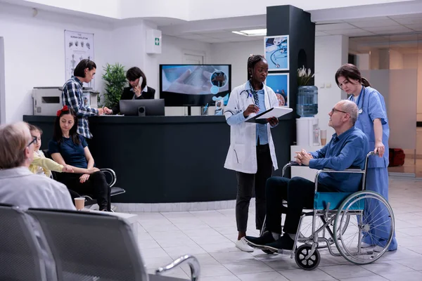 Retired Person Using Wheelchair Being Helped Professional Nurse Talking African — Stock Photo, Image