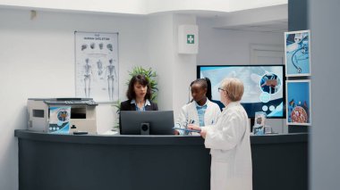 Kıdemli hekim bekleme odasının lobisinde sakat ve sağlık sorunu olan emekli bir hastayla konuşuyor. Felç olmuş tekerlekli sandalye kullanıcısıyla sağlık hizmetleri hakkında konuşmak. El kamerasıyla..