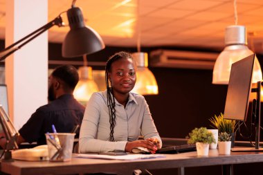 İnternette ağ verisi olan bir araştırma projesinde çalışan kadın çalışanın portresi, ofisindeki büyük pencereli bilgisayarı kullanıyor. Gün batımında web bilgileriyle birlikte evrak hazırlama.