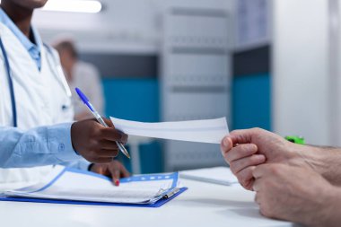 Klinikteki uzman doktoru kapatın. Analiz raporunu ve konsültasyon sonuçlarını kıdemli hastaya verin. Pratisyen hekim hasta yaşlılara tedavi için ilaç verdi.