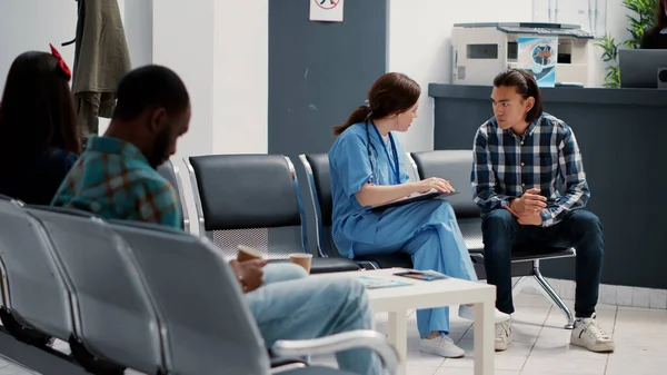 Medical Assistant Filling Checkup Report Talking Asian Patient Hospital Reception — Stockfoto