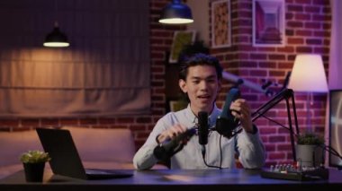 İçerik yaratıcısı kameraya kablosuz kulaklık öneriyor, çevrimiçi kanalda ürün değerlendirme videosu yapmak için kulaklıklardan bahsediyor. Kulaklık önerisiyle podcast vlog kaydı yapılıyor.