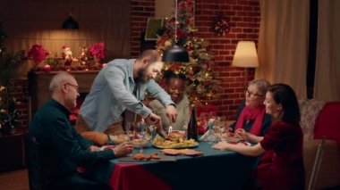 Noel 'i yakın aile üyeleriyle yemek masasında geçirirken kızarmış tavuk kesen neşeli bir ev sahibi. Şenlikli adam Noel tatilinin tadını çıkarıyor. Noel süslemeli dairede akrabaları var..