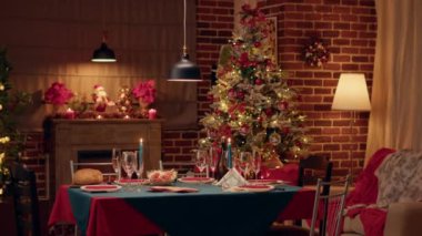 Samimi ve sıcak görünümlü yemek odası, mevsimlik ve pozitifti, içinde kimse yoktu. Orijinal dekorasyonları ve yemek takımlarıyla geleneksel Noel sofrasının içi boş..