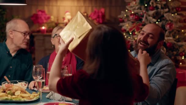 Excited Husband Giving His Wife Present While Enjoying Christmas Dinner — Vídeos de Stock