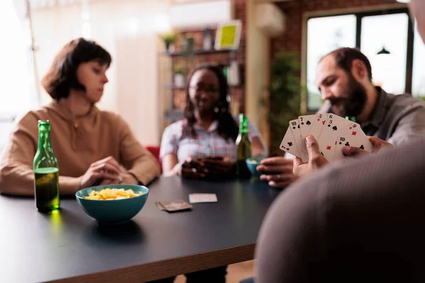 놀이를 하면서 식탁에 즐거운 집단의 친구들 맥주와 간식을 먹으면서 사람들 — 스톡 사진
