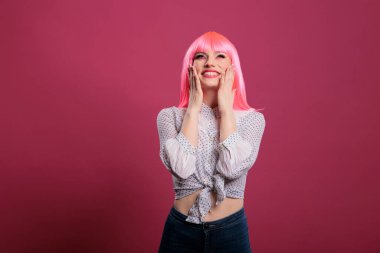 Çekici, şehvetli bir kadının, kamera önünde poz veren portresi. Kendini seksi ve güzel hissediyor. Şık elbiseler, pembe saçlar ve makyajla. Harika bir manken. Şirin ve şık..